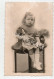 Cpa Photo " Petite Fille Assise Sur Une Table Avec Une Poupée Alsacienne Dans Les Bras ( Photo Tampon Vanackère Lille ) - Giochi, Giocattoli