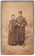 Fotografie H. Ritzmann, Cassel, Eisenbahner In Uniform Mit Mantel Und Mütze Nebst Frau In Einer Winter Studiokulisse  - Anonymous Persons