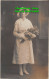 R419623 Woman With A Hat And Gloves And Flowers In Her Hands - World