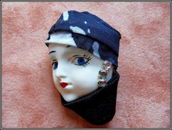 Une Broche Autour D'une Tête De Femme Campée Sous Son Chapeau Noir Et Blanc Et Son Col Assorti. - Broches