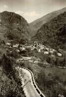 CPSM   SAINT ETIENNE DE TINEE  Le Village  Vue De La Route D'Auron    ,pub A L'arrière L'hotel De La Pinatelle - Saint-Etienne-de-Tinée