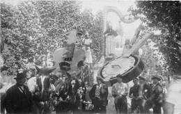 CARTE PHOTO LIEU NON IDENTIFIE REPRESENTANT UNE FETE AVEC UN DEFILE DE CHAR ET INSTRUMENTS DE MUSIQUE GEANTS - To Identify