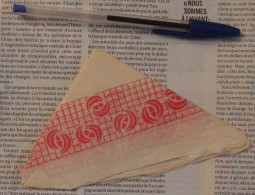 Serviette En Papier Pliée En Triangle Sans Marque Mais Avec Motifs Géométriques Rouges - Servilletas De Papel Con Motivos