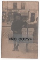 CARTE  PHOTO  -  Jeune Garçon  Sur Un Banc  ( Non Localisée ) Vitrines De Magasins Aux Dos - Silueta