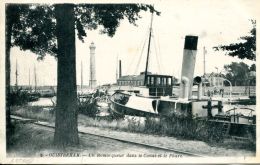 N°1 E -cpa Ouistreham -un Remorqueur Dans Le Canal Et Le Phare- - Tugboats