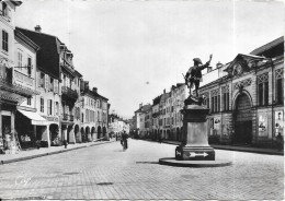 REMIREMONT - 88 -  Grande Rue Et Monument Du Volontaire De 1792 - Cycliste Au 1er Plan - SM - - Remiremont