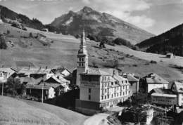 74-LA-CLUSAZ- ENTREE DU VILLAGE VERS LE COL DES ARAVIS DANS LE FOND LE PIC DE L'ETALE - La Clusaz