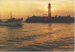 CPM Coucher De Soleil Sur Le Phare Avec Bateau Rentrant Au Port - Phares