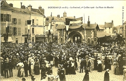 91 DOURDAN FESTIVAL 1 JUILLET 1906 DEVANT LE MARCHE LA PHARMACIE LE FABRICANT DE PARAPLUIE LA CHARCUTERIE CHAUSSURES - Dourdan