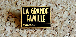 Pin's MEDIA TELE RADIO - CANAL+ émission La Grande Famille - Métal Doré & EMAIL - Fabricant Inconnu - Médias