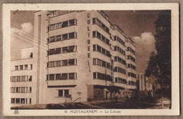 Delcampe - CPA ALGERIE - MOSTAGANEM - Le Colisée - TB PLAN EDIFICE IMMEUBLE Façade + Animation + Oblitération Rajout Timbre 2F - Mostaganem