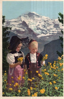 CPA   PETIT GARCON ET PETITE FILLE DANS UN CHAMP DE FLEURS - Cham