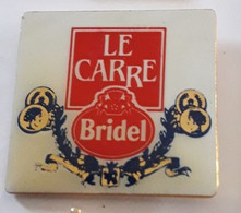 AA452 Pin's Fromage Cheese Le Carré Bridel Lactalis écriture Blanche Sur Fond Rouge Achat Immédiat - Alimentation