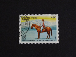 BURKINA FASO YT 660 OBLITERE - ARGENTINA 85 EXPOSITION PHILATELIE CAVALIER ET MONTAGNES CHEVAL HORSE PFERD - Burkina Faso (1984-...)