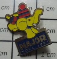 3019 Pin's Pins / Beau Et Rare / ANIMAUX / ELEPHANT JAUNE AVEC BONNET ET ECHARPE MAJOR NOEL 1991 - Animaux
