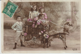 Groupe D'enfants Dans Carriole Fleurie, Tirée Par Chèvre / âne (?) En Peluche "Il Nous Tardait De Vous Fêter" - Children And Family Groups