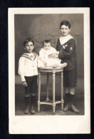 Généalogie - Carte-Photo De 3 Enfants - 2 Garçons Tiennent Leur Petite Soeur Sur Un Guéridon - Genealogia