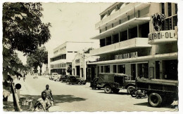 Brazzaville - L'Avenue Du Gouverneur Eboué Et L'Hotêl Métropole ( Animation, Vedette, 202 Peugeot, Jeep) Circ 1953 - Brazzaville