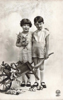 Enfants - Un Frère Et Une Sœur Posant Près D'une Brouette De Fleurs -  Carte Postale Ancienne - Gruppen Von Kindern Und Familien