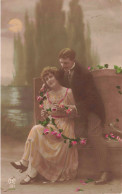 COUPLE - Un Couple Sur Un Banc Dans Un Jardin - Soirée - Roses - Colorisé - Carte Postale Ancienne - Paare