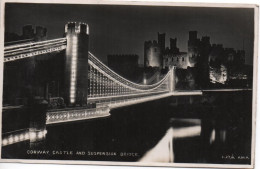 REAL PHOTOGRAPHIC POSTCARD - CONWAY CASTLE AND SUSPENSION BRIDGE AT NIGHT WITH GOOD LLANDUDNO JUNCTION POSTMARK - Caernarvonshire