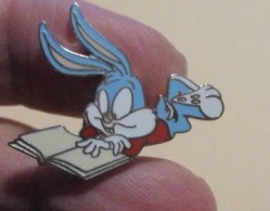 SP D&M Pin's Pins / Beau Et Rare / CINEMA / DESSIN ANIME BUGS BUNNY LISANT LIVRE  Pin's DEMONS & MERVEILLES ETAT NEUF - Kino