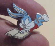 SP D&M Pin's Pins / Beau Et Rare / CINEMA / DESSIN ANIME BUGS BUNNY LISANT LIVRE  Pin's DEMONS & MERVEILLES ETAT NEUF - Films