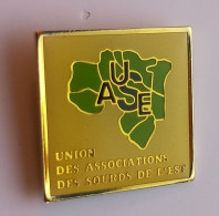 I127 Pin's UASE Union Des Associations Des Sourds De L'est Handicapé Sourd Surdité Malentendant Handicap Achat Immédiat - Geneeskunde