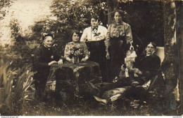 CARTE PHOTO NON IDENTIFIEE REPRESENTANT  DES GENS ASSIS DANS LE JARDIN UN CHIEN SUR LES GENOUX - To Identify