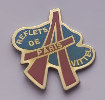 VF03 Pin's Magasin Mode Reflets De Paris Avec Tour Eiffel à VITTEL VOSGES Achat Immédiat - Steden