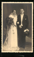 Foto-AK Junges Paar In Hochzeitskleidung Mit Blumenstrauss  - Huwelijken