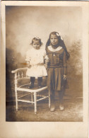Carte Photo D'une Jeune Fille élégante Avec Un Petite Fille Posant Dans Un Studio Photo En 1916 - Personnes Anonymes