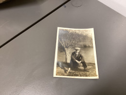 Photo Snapshot 1920 Cannes Homme, Assis Au Bord D’une Rivière Contre Un Arbre Pipe à La Bouche, Jambes écartées - Personnes Anonymes