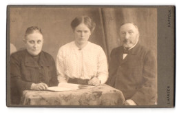 Fotografie L. Hansen, Kappeln, Portrait älteres Paar Und Junge Frau In Hübscher Kleidung Mit Zeitung  - Personnes Anonymes