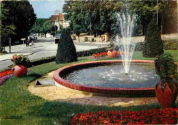 03 - Néris Les Bains - Station Thermale Des Nerfs - Le Carrefour - Massifs Fleuris Et Bassin - CPM - Voir Scans Recto-Ve - Neris Les Bains