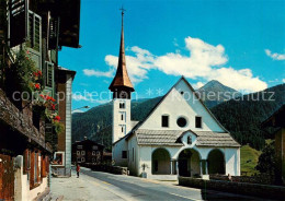 13789860 Muenster Goms VS Dorfstrasse Mit Kirche  - Autres & Non Classés