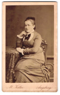 Fotografie M. Keller, Augsburg, Zeuggasse 226b, Elegante Dame Mit Spitzenkragen Und Medaillon, An Einem Tisch Sitzend  - Personnes Anonymes