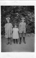 Carte Photo De Deux Petite Fille élégante Avec Un Petit Garcon Posant Dans Leurs Jardin Vers 1920 - Personas Anónimos