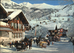 12483973 Lenk Simmental Dorfstrasse Pferdeschlitten Winterpanorama Berner Alpen  - Sonstige & Ohne Zuordnung