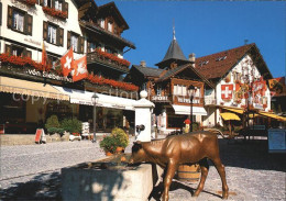 12454940 Gstaad Dorfstrasse Hotel Bronzefigur Brunnen Gstaad - Sonstige & Ohne Zuordnung