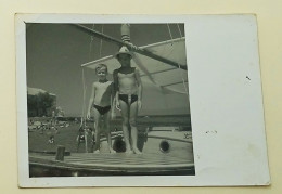 Two Boys Are Standing On A Boat At Sea - Personnes Anonymes