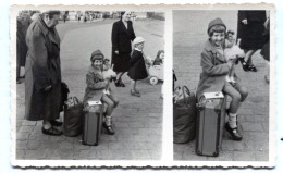 Carte Photo D'une Petite Fille élégante Avec Sa Poupée Assise Sur Sa Valise Dans Une Rue D'une Ville En 1953 - Personnes Anonymes