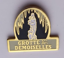 G323 Pin's Dinosaure Préhistoire Spéléologie Grottes Des Demoiselles Massif Du Thaurac Ganges Hérault Achat Immédiat - Städte