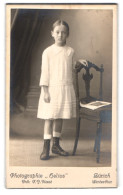 Fotografie Atelier Helios, Zürich, Bahnhofstr. 110, Portrait Hübsches Mädchen Im Kleid Am Stuhl Stehend  - Personnes Anonymes