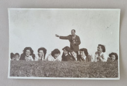 PH - Ph Original - Beaucoup De Jeunes Femmes Allongées Sur L'herbe Tandis Qu'un Homme Sourit Derrière Elles 1950 - Anonyme Personen