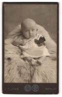 Fotografie J. Fuchs, Berlin, Portrait Süsses Baby Im Weissen Hemd Auf Fell Sitzend  - Persone Anonimi