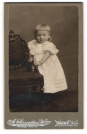 Fotografie A. Sincelius, Dahme I. Mark, Kleines Mädchen Mit Blonden Haaren Trägt Weisses Kleid Und Steht An Sessel  - Persone Anonimi