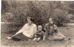 Carte Photo De Deux Jeune Fille élégante Avec Un Petit Garcon Posant Dans L'herbe Dans Leurs Jardin - Personnes Anonymes