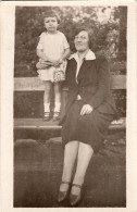 Carte Photo D'une Femme élégante Avec Sa Petite Fille Posant Sur Un Banc Dans Un Jardin Public - Personnes Anonymes