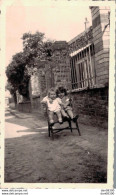 PHOTO DE 11 X 6.5 CMS UNE FILLETTE AVEC UNE HOUPETTE ASSISE DANS LA RUE SUR UN FAUTEUIL EN ROTIN MAI 1943 - Anonyme Personen